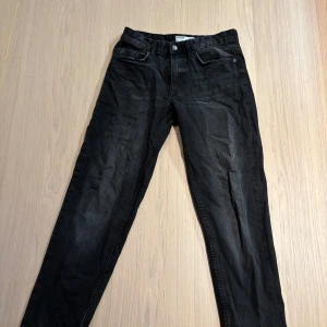 Svarta straight jeans från Bershka - Säljer ett par svarta straight fit jeans från Bershka i vintage-stil. Jeansen har klassisk femficksdesign, bälteshällor och dragkedjegylf. Materialet är denim och färgen är snyggt tvättad svart. Perfekta för en chill och stilren look.