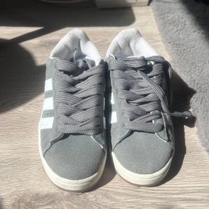Grå Adidas Campus sneakers - Snygga Adidas Campus sneakers i grå mocka. Dem är i storlek 38 och är aldrig använde bara till för prövning💕💕 
