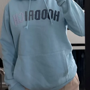 Ljusblå hoodie från Hoodrich - Säljer en ljusblå hoodie från Hoodrich i storlek S. Tröjan har broderad logga framtill och gömd liten ficka i vänster arm. Mjuk bomullskänsla och långärmad modell.  INGA fläckar/hål osv. 