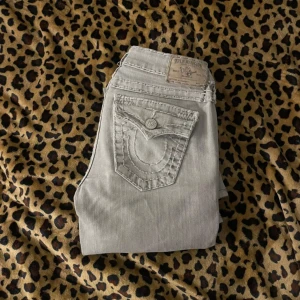 True Religion Jeans - Säljer ett par ljus gråa trueys! Dom är lowwaist och bootcut🔮Midjemått rakt över 35cm . Innerbenslängd 70cm.🎀