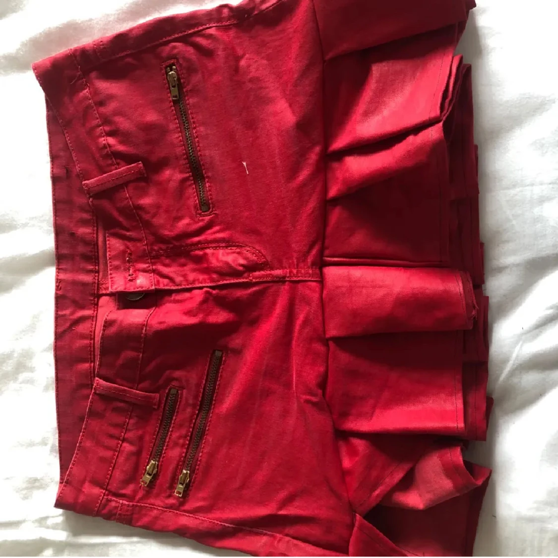 Röd plisserad minikjol med dragkedjor