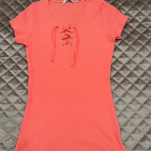 Topp med snörning - Snygg korall/rosa/röd topp med korta ärmar och cool snörning fram vid halsen. passar perfekt till sommaren.💖 köpt på Vinted aldrig använd! Märket är FB sister💖