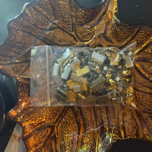Mixade smyckesdelar i guld och silver - En påse med mixade smyckesdelar i både guld- och silverfärg. Perfekt för dig som vill skapa egna armband, halsband eller örhängen. Delarna har en räfflad yta och är små och smidiga att använda till DIY-projekt.