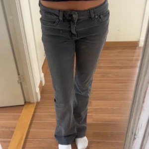 Grå bootcut jeans från Junkyard - Snygga grå jeans från Junkyard med bootcut passform och klassisk femficksdesign. Jeansen har en mörkgrå tvätt, normal midja och coola bakfickor med unik söm. Knappt använda
