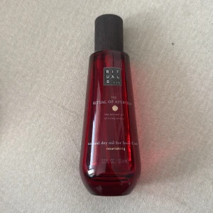 Rituals The Ritual of Ayurveda olja - Röd flaska med naturlig torr olja för kropp och hår från Rituals, The Ritual of Ayurveda. Innehåller 100 ml och har en elegant, mörkbrun kork. Oljan är närande och passar perfekt för dig som vill boosta både hud och hår med extra glow.