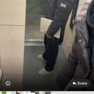 Svart pufferjacka från Burberry - Snygg svart pufferjacka från Burberry med klassiskt rutigt foder i huvan och logga på ärmen. Jackan har dragkedja, knappar och två fickor framtill. Perfekt för kalla dagar när du vill hålla stilen och samtidigt vara varm.
