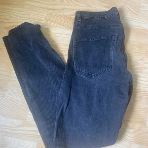 Svarta raka jeans - Snygga svarta jeans med klassisk femficksdesign och raka ben. Jeansen har en mörk tvätt och är tillverkade i ett robust jeanstyg som passar perfekt till en avslappnad stil.
