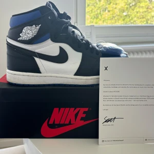 Nike Air Jordan 1 Retro High OG Royal - Nike Air Jordan 1 Retro High OG i svart, vitt och blått skinn. Köpta på StockX. Kommer med orignalsnören och kartong! Använt väldigt sparsamt och inte använt på över 1 år! 