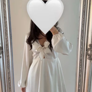 Vit omlottklänning i satin - Superfin vit klänning i glansig satin med lång ärm och v-ringning. Omlottmodell med knyt framtill och lätt utsvängd kjol. Slutsåld på Gina Tricot, aldrig använt den men har ingen prislapp kvar. 