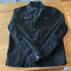 Svart jeansjacka från Denim Project - Snygg svart jeansjacka från Denim Project med klassisk krage, silverfärgade knappar och två bröstfickor. Aldrig använd, liten L