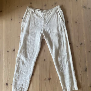 Beiga linnebyxor från Zara, storlek L - Snygga beiga linnebyxor från Zara i storlek L. Byxorna har en avslappnad passform med raka ben, sidfickor och resår baktill i midjan. Perfekta för varma dagar och ger en chill vibe med sitt tunna linnematerial.