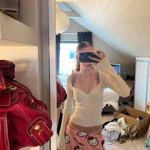 Ribbad beige långärmad tröja - Supersnygg ribbad tröja i beige med djup v-ringning och långa ärmar. Tröjan har en figurnära passform och är tillverkad i ett stretchigt stickat material som sitter riktigt snyggt på kroppen. Perfekt att styla med jeans eller kjol för en trendig look. vet verkligen inte vilket märke då lappen är bortklippt❤️🫶💕