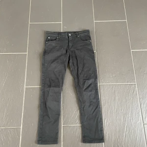 Cheap Monday - Svarta slim jeans - Svarta jeans med smal passform och klassisk femficksdesign. Byxorna har normal midja och raka ben som smalnar av mot ankeln. Tillverkade i ett stretchigt bomullsmaterial för extra komfort. Perfekta för en clean och stilren look.