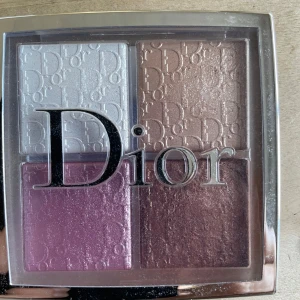 Dior Backstage Glow Face Palette - Dior Backstage Glow Face Palette med fyra nyanser: vit och guldig highlighter, rosa rouge och bronzig blush. Paletten har lyxig design med Dior-logga på varje ruta och passar perfekt för att skapa glowiga och fräscha looks.