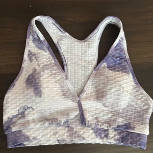 Mönstrad sporttopp från Shein - Säljer en snygg sporttopp från Shein i ett lila och vitt mönster. Toppen har en ribbad textur och brottarrygg för extra komfort under träning. Perfekt för gymmet eller yoga!