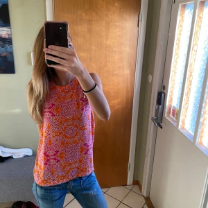 Mönstrad ärmlös topp i orange och rosa - Säljer en färgglad ärmlös topp med ett detaljerat mönster i orange, rosa och vitt. Skriv för frågor 💕💕storlek Small