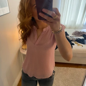 Rosa blus  - Säljer en söt rosa blus med korta ärmar. Perfekt för en avslappnad men stilren look. Blusen har en lätt och luftig passform.