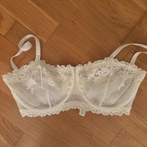 BH Intimissimi  - Säljer en elegant vit bh med vacker spetsdetalj. Den har justerbara axelband och en fin passform som ger bra stöd. Perfekt för att känna sig extra fin till vardags eller speciella tillfällen. I den poplära kollektionen ”pretty flowers”. Aldrig använd då den är för liten för mig. Storlek 80D