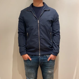 Mörkblå Jack & Jones jacka  - Säljer denna snygga jacka från Jack & Jones för 499kr, perfekt inför våren. Skicket är väldigt bra, använd men inga större defekter (9/10) och är i storlek M. Om ni har några frågor så är det bara att höra av sig!