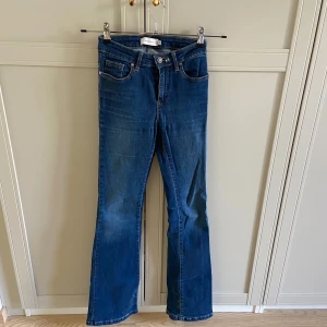 Blå bootcut jeans från Scalpers - Snygga blå bootcut jeans från Scalpers med ett litet dödskallebroderi på bakfickan. Rätt så stretchiga i materialet så de är inte nödvändigtvis så smala i bena som de ser ut, de passar alltså större och smalare! De har en missfärgning av en snusdosa på höger bakficka. Utöver det är de i bra skick!💕liknande jeans från scalpers ligger på ungefär 900kr på Zalando 