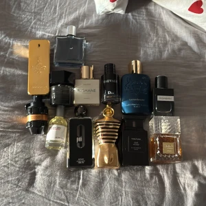 Samling av parfymer - En samling av olika parfymer i varierande flaskor och design. Inkluderar märken  har olika former och färger, inklusive guld, svart och blå. Perfekt för den som vill ha en varierad doftgarderob.