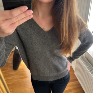 Grå kashmirtröja från Soft Goat - Grå kashmirtröja från Soft Goat. Tröjan har en v-ringad design och långa ärmar. Den är mjuk och bekväm. Storlek M men sitter som XS!!!!