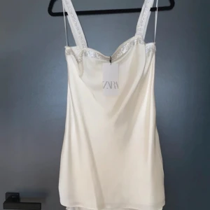 Vit klänning med glitter - Superfin klänning med glitter detalj vid brösten. 