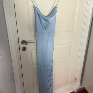 Ljusblå långklänning med smala axelband - Elegant ljusblå långklänning med smala axelband. Perfekt som balklänning! Aldrig använd, prislapp kvar!