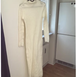 Vit ribbad långklänning från MNG - Säljer en stilren vit ribbad långklänning från MNG. Klänningen har långa ärmar och en hög krage, perfekt för kyligare dagar. Med polo hals och slits. Den är både bekväm och elegant, vilket gör den till ett mångsidigt tillskott i garderoben.