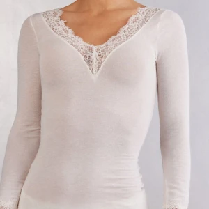 Intimissimi tröja med spets - Elegant vit långärmad topp med v-ringad spetsdetalj. Perfekt för en stilren look. Aldrig använd, säljer då jag inte passade i färgen.