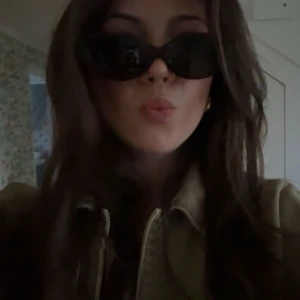 Svarta solglasögon med oval form - Snygga svarta solglasögon med en stilren oval form. Perfekta för att ge en cool touch till din outfit. De har en glansig finish och passar de flesta ansiktsformer.