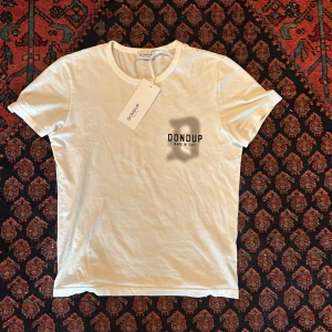 Vit t-shirt från Dondup - Snygg vit t-shirt från Dondup med tryck 'Made in Italy' på bröstet. Perfekt för en stilren look. T-shirten har en klassisk rund hals och korta ärmar.