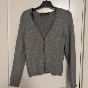 Grå kofta från ONLY - Säljer en grå kofta från ONLY. Den har en v-ringad design och långa ärmar, perfekt både för våren och sommaren. Koftan är tillverkad i ett mjukt material som ger en bekväm passform. Har ni frågor så skriv till mig och pris går att diskutera!💗