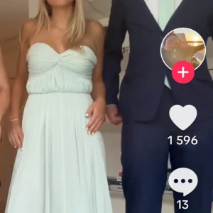 Mintgrön balklänning  - Elegant mintgrön långklänning från Gina tricot med axelbandslös design och vacker drapering framtill. Perfekt för speciella tillfällen med sin flytande och luftiga stil. Klänningen har en mjuk och bekväm passform som ger en sofistikerad look.