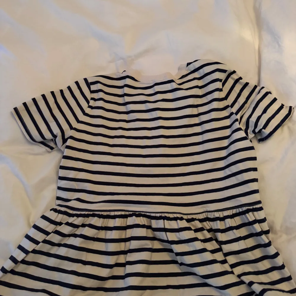 Säljer en randig topp från Zara i svart och vit. Toppen har korta ärmar och en volangdetalj vid midjan som ger en fin form. Perfekt för en avslappnad stil.. Yläosat.