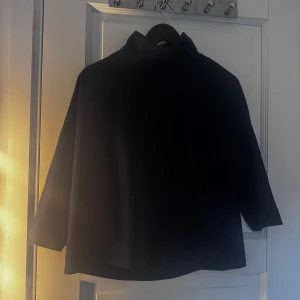 Blå polotröja från Carin Wester - Snygg svart polotröja från Carin Wester i storlek XS. Perfekt för en stilren look med sin enkla design och bekväma passform. Tröjan har långa ärmar och en klassisk polokrage.