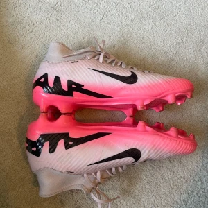 Nike fotbollsskor  - Säljer ett par rosa Nike fotbollsskor som va trendiga. Står storlek 41 men absolut inte 41. Jag har 39 och de passar perfekt på mig!  Använda hyfsat. Se undersida, att de är lite slitna under. Annars bra skick. Inte smutsiga.💕