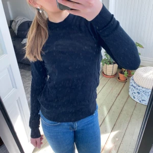 Svart tröja från 157 - Säljer en svart tröja från 157 i storlek XS. Tröjan har en klassisk design med långa ärmar och ribbade muddar vid ärmslut och hals. Perfekt för en stilren look. Håll under en armhåla vid sömnen som enkelt  går att sy igen