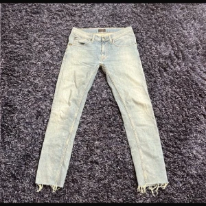  Tiger of Sweden Pistolero - Säljer ett par ljusblå jeans från Tiger of Sweden i modellen Pistolero. Jeansen har raka ben med slim fit, klassisk femficksdesign och fransade benslut för en riktigt bra wash. Perfekta för dig som gillar stilrena men ändå unika jeans. Storlek 31/32. Pris kan diskuteras.