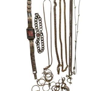 Smyckespaket med klocka, halsband, armband och ringar - Stort smyckespaket med blandade smycken i silver- och guldfärg. Innehåller en Gucci-klocka med rosa urtavla, flera kedjehalsband, armband och ringar. Några halsband har vita pärldetaljer. Perfekt för dig som vill variera din stil.