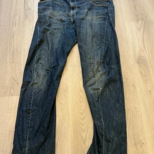 Levi's Engineered Jeans i mörkblå denim - Mörkblå jeans från Levi's Engineered Jeans med klassisk femficksdesign och raka ben. Jeansen har en snygg tvätt och normal passform, perfekta till vardags. Midjan är normal och materialet är slitstark denim.
