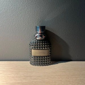 Valentino Born in Roma Uomo intense - Säljer en Valentino Born in Roma Uomo intense i en mörkgrå glasflaska med nitar och metallisk etikett. Flaskan har en lyxig och snygg design som sticker ut på hyllan. Perfekt för dig som gillar en klassisk doft. (Kolla bild 2 för att se hur mycket det är kvar) pris kan diskuteras