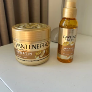 Pantene Pro-V Keratin Protect Oil och Hårinpackning - Säljer ett set med Pantene Pro-V Keratin Protect Oil och en hårinpackning. Båda produkterna är guld- och vitfärgade med keratin, perfekta för att ge näring och glans till håret. Oljan kommer i en genomskinlig plastflaska med pump och inpackningen i en rund burk. Se mängd kvar på bilderna!!