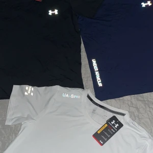 Under Armour t-shirt i olika färger - Säljer snygga Under Armour t-shirts i svart, blått och vitt, finns även i grå färg. Säljer 1 T-shirt för 350kr och alla är i storlek M. Perfekt för träning eller sport aktiviter. Shorts matchande till tröjan får jag även in snart, de kommer att kosta 250kr styck. De kommer med kvitto och med påse.