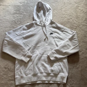 Vit hoodie från Nike - Säljer en klassisk vit hoodie från Nike med svart logga på bröstet. Storleken är S/M 