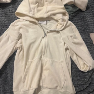 juicy couture hoodie - Jätte fin bild vit beige juicy hoodie, säljs på grund av att den inte används längre. Den är knappt använd. Bra kvalitet. Storlek 12/13, men funkar som xs/s. Skriv om du har funderingar!🫶 Original priset:1100kr