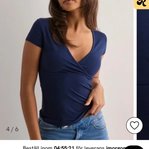 Mörkblå omlottopp med kort ärm - Säljer denna populära toppen från Nelly i stl XS. Den är som ny! Mer info vid intresse💞💞 