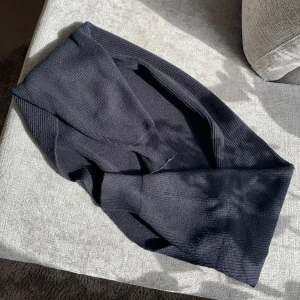 Svart stickad bolero - En svart stickad kofta med lång ärm. Koftan är gjord i ett mjukt, mysigt material. Passar perfekt till elegant klänning som till yoga passet. 