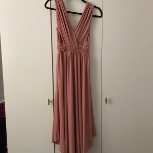Rosa balklänning från Chiara Forthi - Säljer en elegant rosa långklänning från Chiara Forthi med djup v-ringning och breda axelband. Skulle säga att den riktiga färgen stämmer bäst överens på tredje bilden. Kontakta mig för frågor eller fler bilder💞