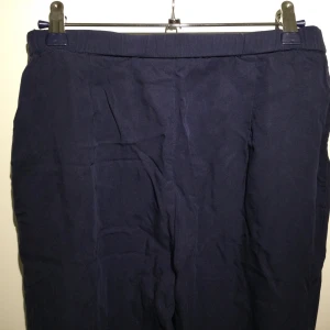 Mörkblå byxor från KappAhl 38 - Blå raka byxor från KappAhl Lyocell Dold dragkedja i sidan 2 fickor fram Beninnerlängd: 78 cm 2 små hål på baksidan, se bild 5 ( i höjd med knät)